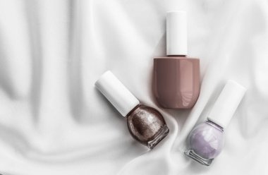 İpek arka planda oje şişeleri, Fransız manikür ürünleri.