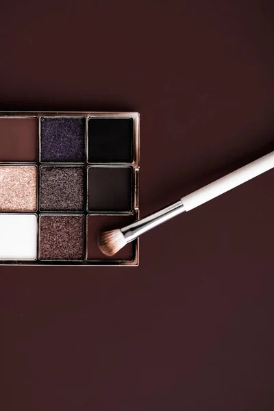 Paleta de sombra e pincel de maquiagem no fundo de chocolate, olho — Fotografia de Stock
