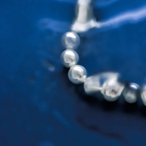 Bijoux côtiers mode, collier de perles sous fond bleu marine — Photo