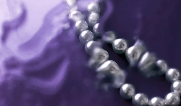 Прибережна ювелірна мода, перлове намисто під фіолетовим водяним списом — стокове фото