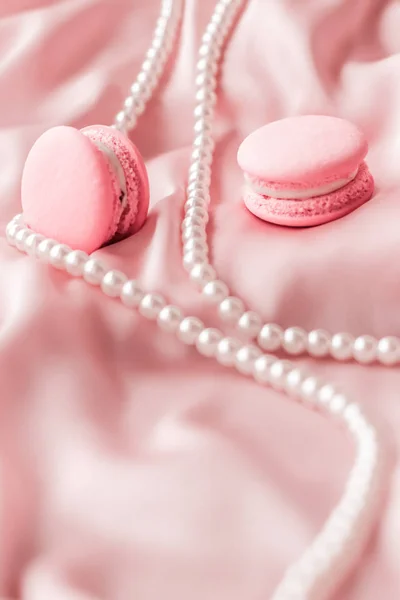 Sweet macaroons and pearls jewellery on silk background, parisia — ストック写真