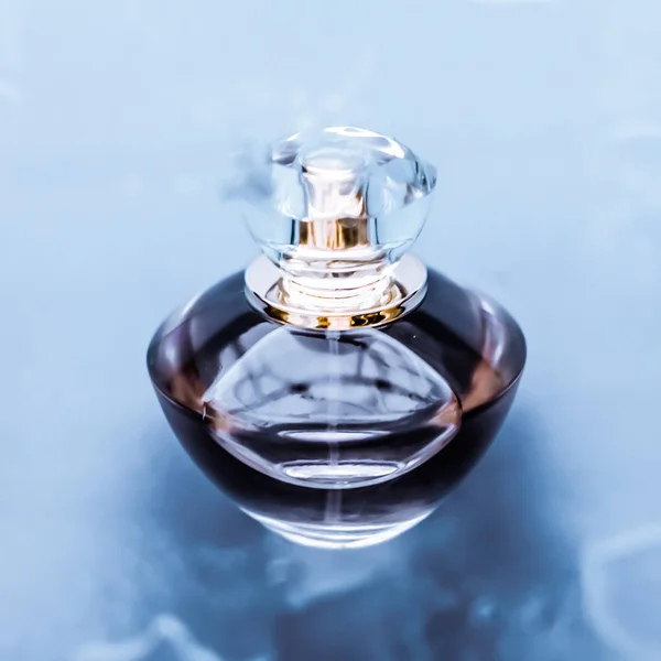 Butelka perfum pod błękitną wodą, świeży morski przybrzeżny zapach jako glam — Zdjęcie stockowe