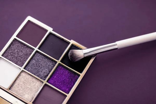 Eyeshadow palette and make-up brush on purple background, eye sh