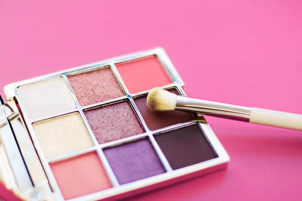Paleta de sombra de ojos y pincel de maquillaje sobre fondo rosa, sombra de ojos — Foto de Stock