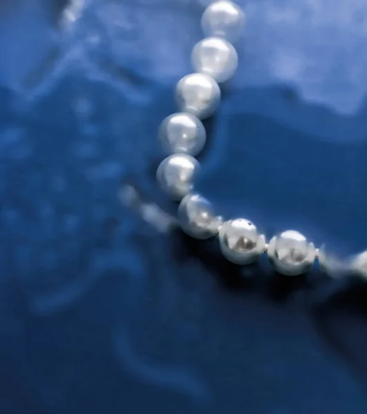 Moda de joyería costera, collar de perlas bajo respaldo de agua azul — Foto de Stock