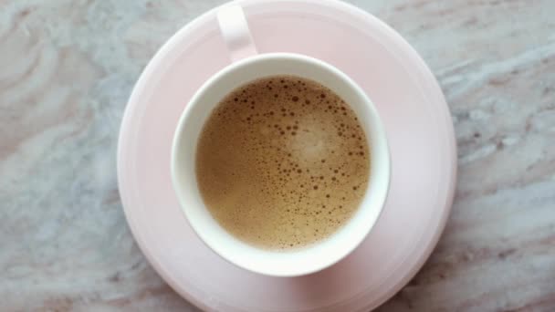 Cangkir kopi pagi dengan susu di atas batu marmer rata, minuman panas di atas flat meja, top melihat videografi makanan dan inspirasi resep untuk memasak vlog — Stok Video