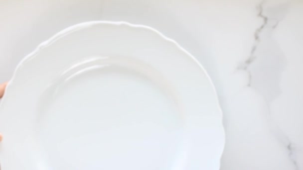 Пустые белые фарфоровые тарелки на мраморном столе, столовые украшения ужин лежа, вид сверху пищевая видеография, как рецепт вдохновения для приготовления vlog или flatlay меню — стоковое видео