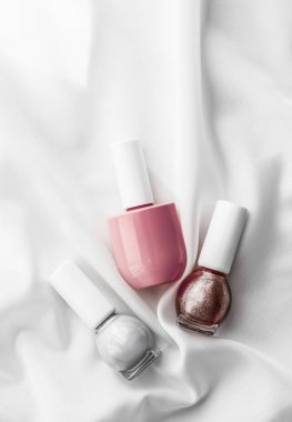 İpek arka planda oje şişeleri, Fransız manikür ürünleri.