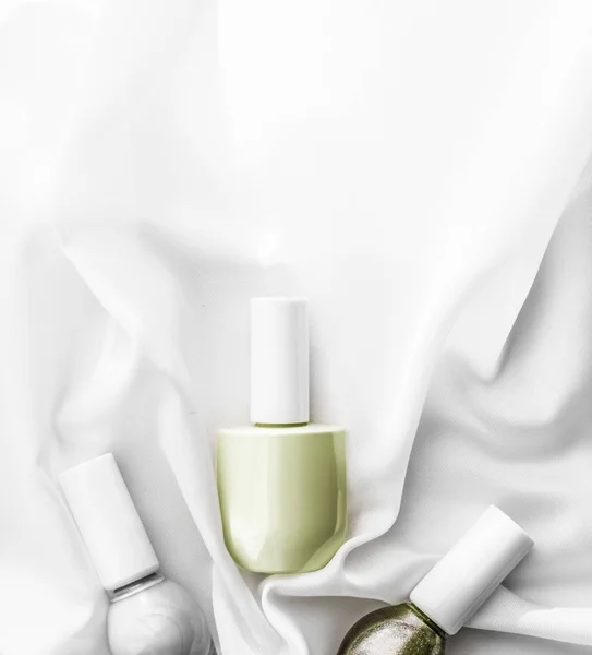 Nagellak flessen op zijde achtergrond, franse manicure producten — Stockfoto