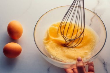 Ev yapımı yemek olarak mermer masada yumurta karıştırmak.