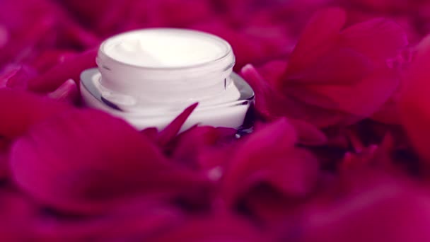 Creme de rosto hidratante de cuidados com a pele sensível em pétalas de flores e fundo de água, ciência natural para a pele — Vídeo de Stock