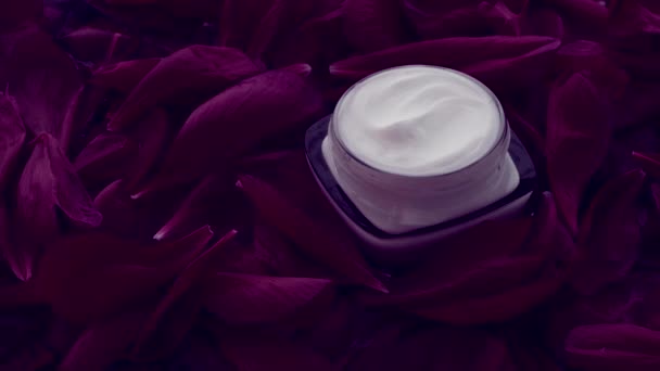 Crema facial hidratante para el cuidado de la piel sensible sobre pétalos de flores y fondo de agua, ciencias naturales para la piel — Vídeos de Stock