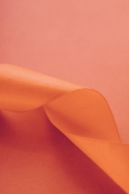 Turuncu arka planda soyut kıvrımlı ipek kurdele, özel lüks.