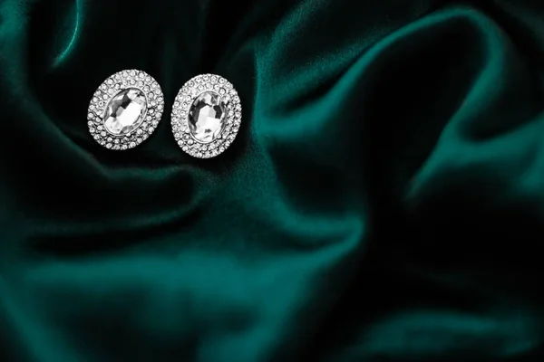 Pendientes de diamantes de lujo en seda verde esmeralda oscura, glamour navideño —  Fotos de Stock