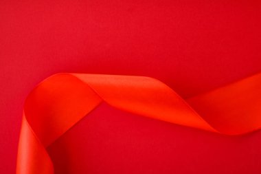 Kırmızı arka planda soyut kıvrımlı ipek kurdele, özel lüks b