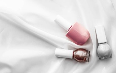 İpek arka planda oje şişeleri, Fransız manikür ürünleri.