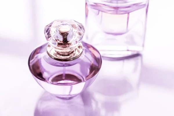 Μοβ μπουκάλι άρωμα σε γυαλιστερό φόντο, γλυκό άρωμα λουλουδιών, — Φωτογραφία Αρχείου