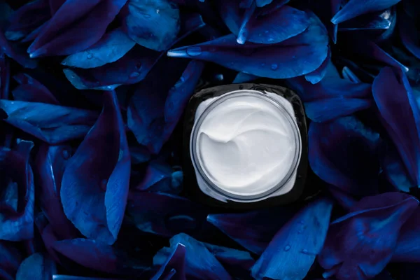 Розкішний крем для обличчя зволожувач для шкіри обличчя на синій квітковий спині — стокове фото