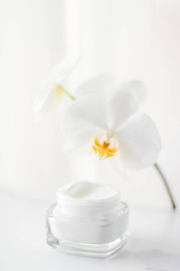 Face cream moisturizer jar and orchid flower, moisturizing skin  clipart