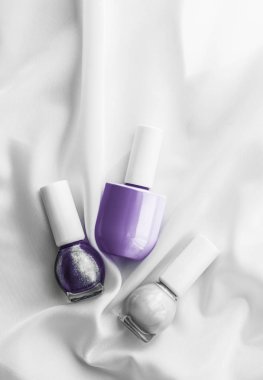 İpek arka planda oje şişeleri, Fransız manikür ürünleri.