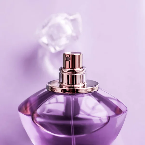 Фіолетова пляшка парфумів на глянсовому фоні, солодкий квітковий запах , — стокове фото