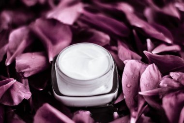 Pembe çiçek çantasındaki yüz kremi nemlendiricisi.
