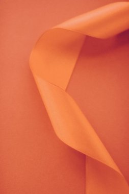 Turuncu arka planda soyut kıvrımlı ipek kurdele, özel lüks.