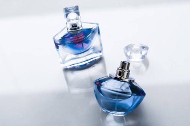 Parlak arka planda mavi parfüm şişesi, tatlı çiçek kokusu, gl
