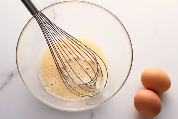 Виготовлення змішування яєць у мисці на мармуровому столі як домашньої їжі f — стокове фото