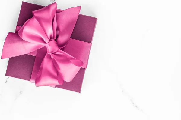 Pink gift box with silk bow on marble background, girl baby show — Stock Photo, Image