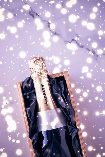 Bouteille de champagne et boîte cadeau sur des paillettes de vacances violettes, New Yea — Photo
