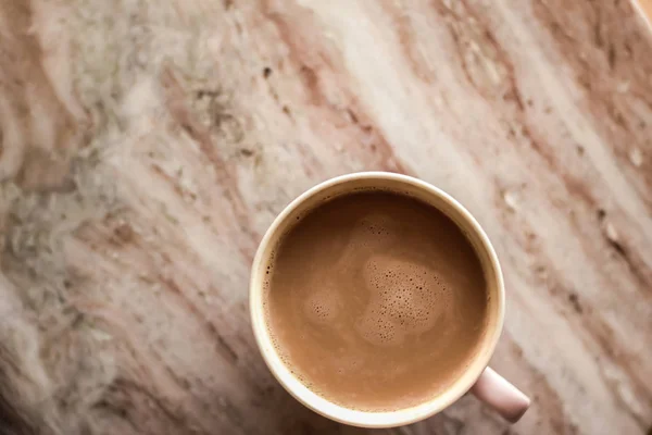 Taza de café de la mañana con leche en piedra de mármol plano laico, bebida caliente — Foto de Stock
