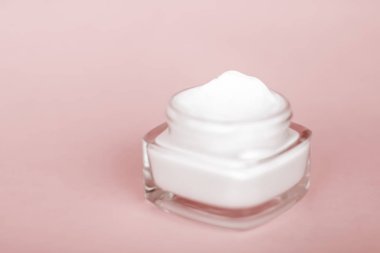 Bej arka planda yüz kremi nemlendirici kavanozu, nemlendirici kayak