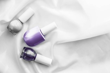 İpek arka planda oje şişeleri, Fransız manikür ürünleri.