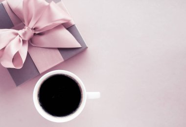 Allık pembe arka plan üzerinde Lüks hediye kutusu ve kahve fincanı, flatlay