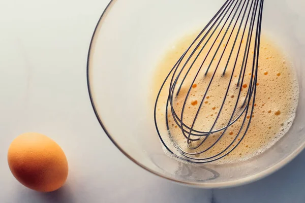 Membuat telur campur dalam mangkuk di atas meja marmer sebagai makanan buatan sendiri f — Stok Foto