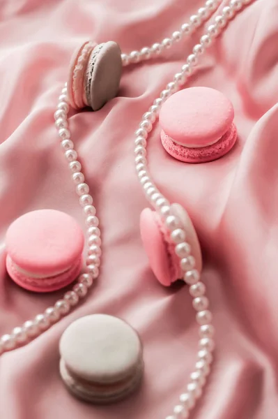 Sweet macaroons and pearls jewellery on silk background, parisia — ストック写真