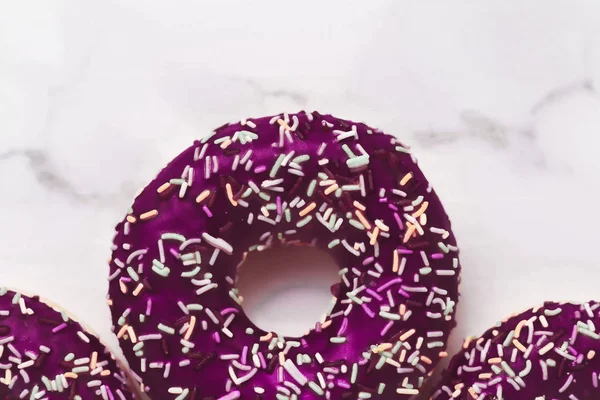 Donuts glacés saupoudrés, dessert pâtissier sucré sur table en marbre b — Photo