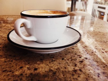 Kafeteryada kahvaltı için Cappuccino, pa masada kahve fincanı