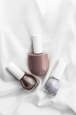 İpek arka planda oje şişeleri, Fransız manikür ürünleri.