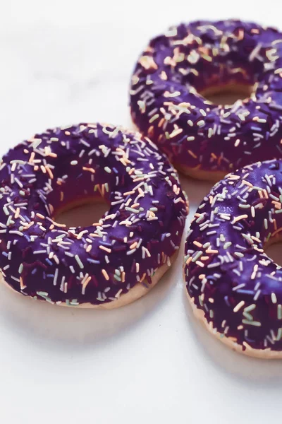 Milchig bestreute Donuts, süßes Gebäck Dessert auf Marmortisch — Stockfoto