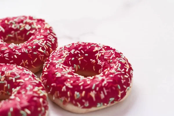 Milchig bestreute Donuts, süßes Gebäck Dessert auf Marmortisch — Stockfoto