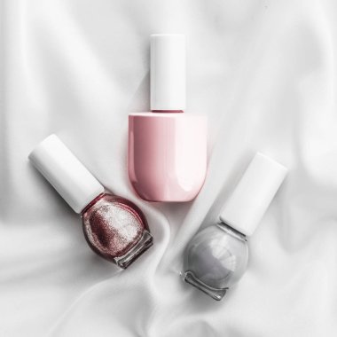 İpek arka planda oje şişeleri, Fransız manikür ürünleri.