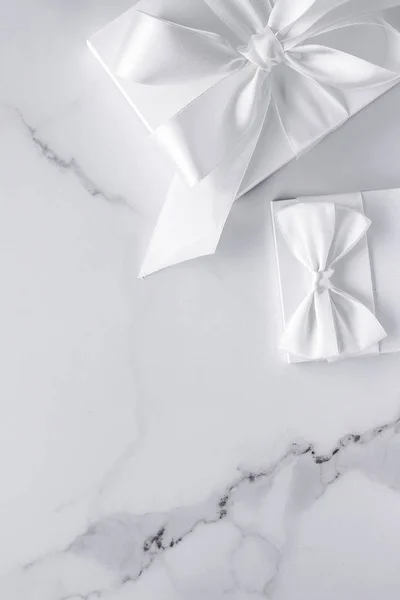Luxus-Hochzeitsgeschenke mit Seidenschleife und Bändern auf Marmorboden — Stockfoto