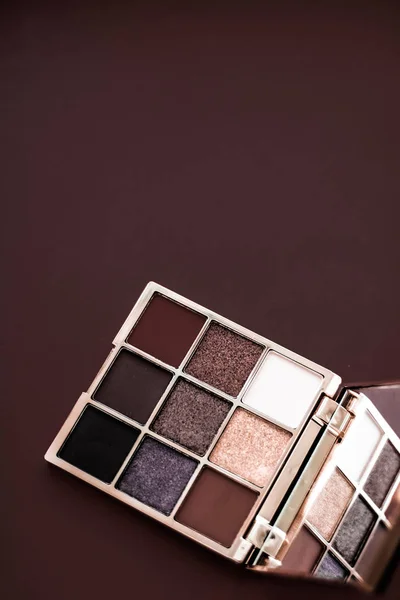 Eyeshadow palette and make-up brush on chocolate background, eye — Stock Photo, Image