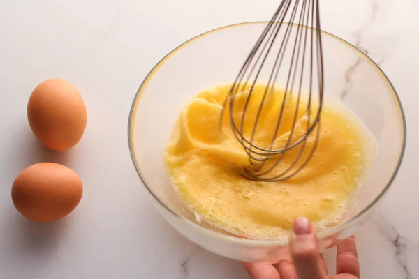 Виготовлення змішування яєць у мисці на мармуровому столі як домашньої їжі f — стокове фото