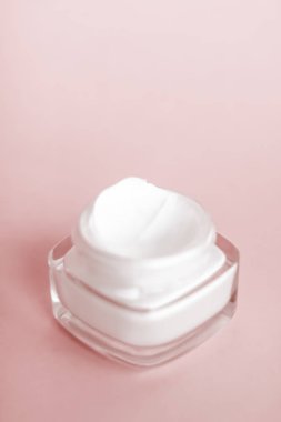 Bej arka planda yüz kremi nemlendirici kavanozu, nemlendirici kayak