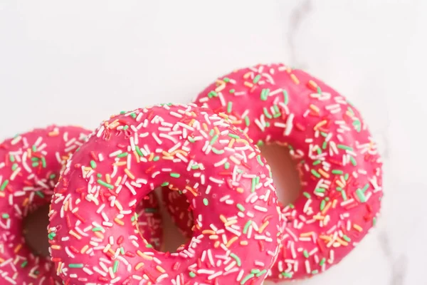 Milchig bestreute Donuts, süßes Gebäck Dessert auf Marmortisch — Stockfoto