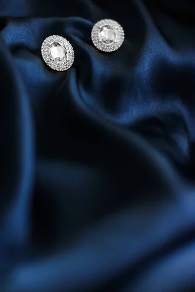 Pendientes de diamantes de lujo sobre fondo de seda azul oscuro, gl vacaciones —  Fotos de Stock