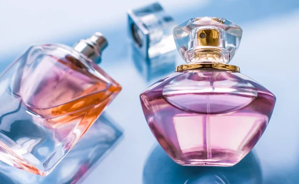 Bottiglia di profumo rosa su sfondo lucido, dolce profumo floreale, gl — Foto Stock